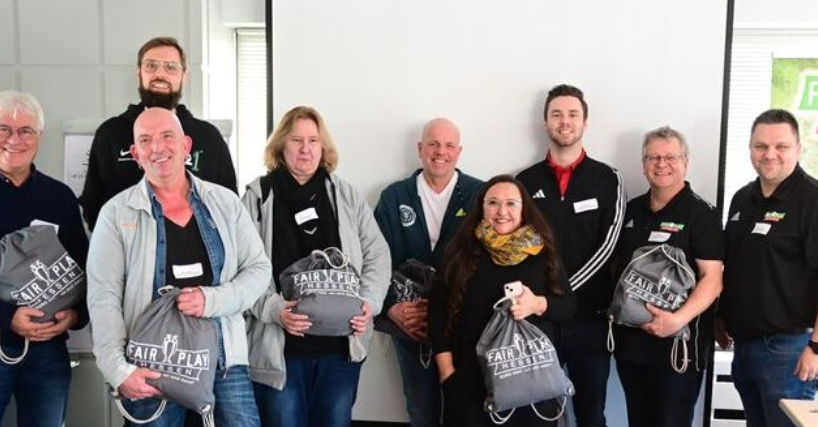 Gruppe mit Fair-Play-Materialien bei einer Veranstaltung im Sport
