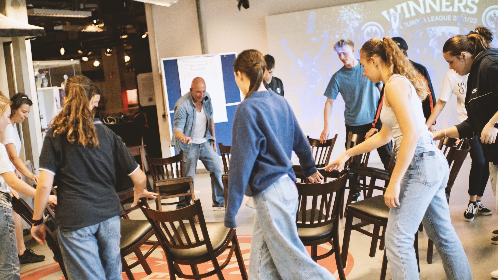 Gemeinsame Übung mit Stühlen in einer Workshopgruppe
